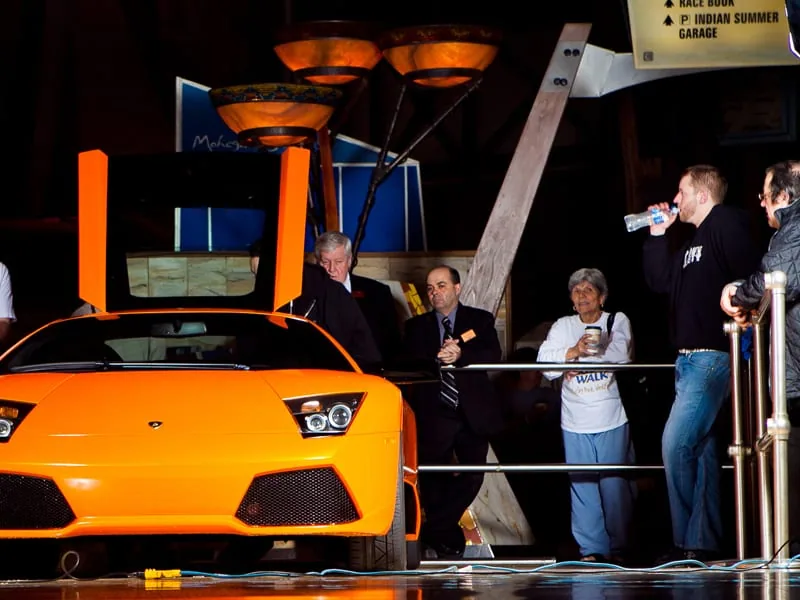Orange Lamborghini Murciélago with scissor door open on a polished casino floor at Mohegan Sun