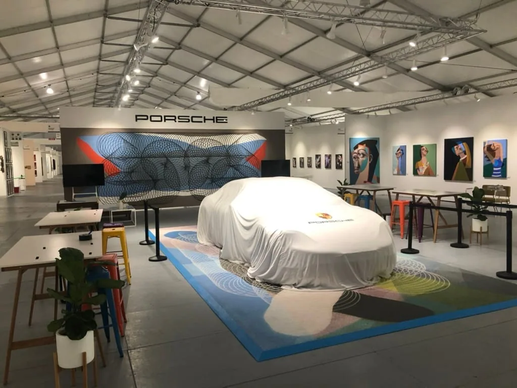 White Porsche Mission E concept on a parquet platform with Tribute to tomorrow branding at Miami Art Week